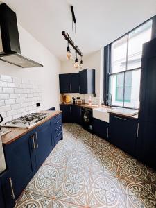 een keuken met blauwe kasten, een wastafel en een fornuis bij Luxury Apartment in the heart of Newcastle centre in Newcastle upon Tyne