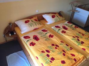 twee bedden in een kamer met rode bloemen erop bij Ferienhaus Walther in Erbach