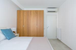 Schlafzimmer mit einem Bett und einem Holzschrank in der Unterkunft Starhost - Mazzini Apartments in Salerno