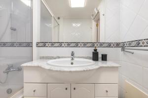 ein weißes Badezimmer mit Waschbecken und Dusche in der Unterkunft Sunny 2 BDR Apartment by LovelyStay in Charneca + 39 Fotos