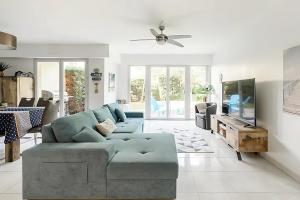 a living room with a blue couch and a tv at Rooftop pool, private garden, at the sand beach! in Antibes