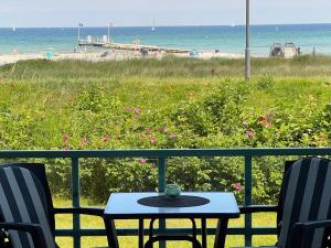 a table and chairs on a balcony overlooking the beach at Steiner Strandappartements Studio-Appartement 104 Seeseite in Stein