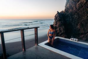 a woman in a bikini sitting in a bath tub on the beach at Casa de Mar Hotel And Villas in La Libertad
