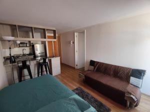 a living room with a couch and a kitchen at Copernico amoblado 1Dormi. 4 personas 1Est in Antofagasta
