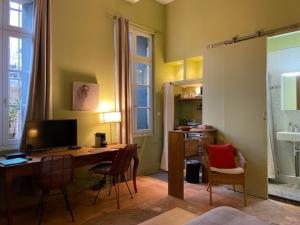 Cette chambre comprend un bureau avec un ordinateur et des chaises. dans l'établissement Peyrou, studio la merci, 3 étoiles, à Montpellier