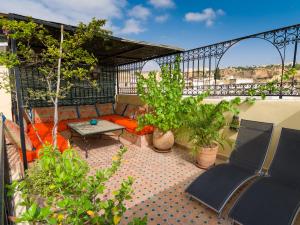 a patio with a couch and a table on a balcony at Riyad Al Atik in Fez