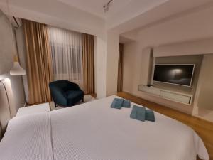 ein Hotelzimmer mit einem Bett und einem TV in der Unterkunft Apartment Gorazd in Skopje
