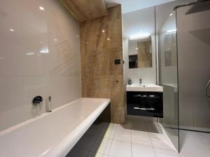 a white bathroom with a tub and a sink at Copernicus Dream Apartment Toruń Stare Miasto in Toruń