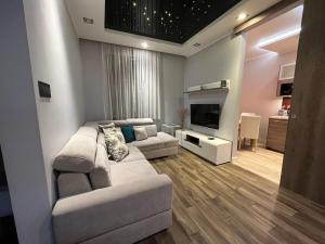 a living room with a couch and a tv at Copernicus Dream Apartment Toruń Stare Miasto in Toruń