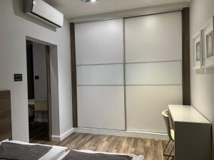 a sliding glass door in a bedroom with a desk at Copernicus Dream Apartment Toruń Stare Miasto in Toruń
