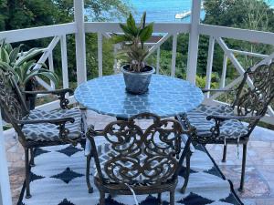 een tafel en twee stoelen en een potplant op een veranda bij Columbus Heights A5 in Ocho Rios