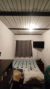 1 dormitorio con 1 cama y TV en Apartamento Cómodo y Familiar, en Medellín