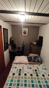 Habitación pequeña con cama y escritorio. en Apartamento Cómodo y Familiar, en Medellín