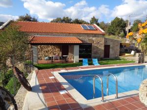 a house with a swimming pool in front of it at Casa Entre-Palheiros e Casa do Canastro in Montalegre