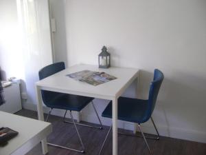 a white table with two chairs and a paper on it at Appartement Corniche I 40 M2 - 40 M de l'eau ! AU CALME wir sprechen flieBen deutsch, Touristentipps, we speak English in Concarneau
