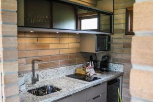 a kitchen with a sink and a microwave at Mirador da Montanha in Praia Grande