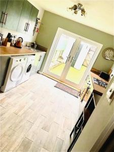 a kitchen with a washer and dryer in a room at Cosy home near Caerphilly 