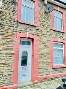 a brick building with a white door and windows at Cosy home near Caerphilly 