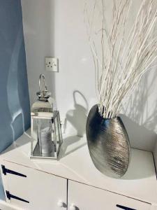 a vase sitting on top of a white cabinet at Cosy home near Caerphilly 