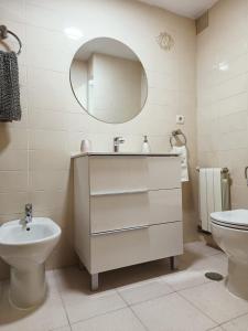W łazience znajduje się umywalka, toaleta i lustro. w obiekcie PISO EL SERRALLO w Grenadzie