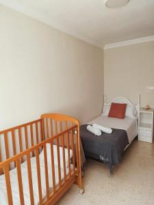 a small bedroom with a bed and a crib at PISO EL SERRALLO in Granada