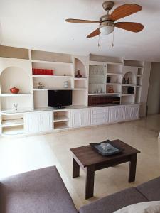 - un salon avec un ventilateur de plafond et une table dans l'établissement PISO EL SERRALLO, à Grenade