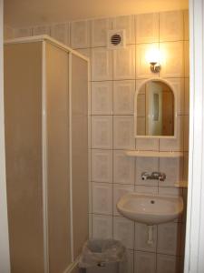 a bathroom with a sink and a shower with a mirror at Pokoje Gościnne Standard in Jastrzębia Góra