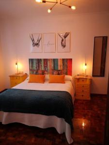 1 dormitorio con 1 cama con 2 mesitas de noche y 2 lámparas en Apartamento Alecrin Padrón, en Padrón