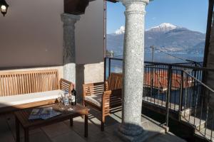a balcony with a table and chairs and a view of mountains at Casa Pina in Menaggio
