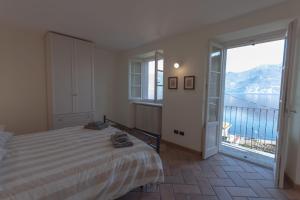a bedroom with a bed and a large window at Casa Pina in Menaggio