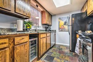 a kitchen with wooden cabinets and a black refrigerator at Sunset-View Resort Condo on Lake Hamilton! in Hot Springs