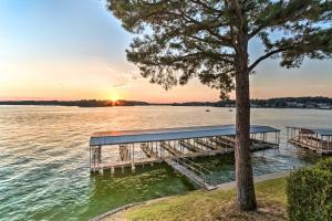 a dock on a lake with a tree at Sunset-View Resort Condo on Lake Hamilton! in Hot Springs