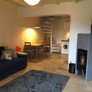 a living room with a couch and a table with a fireplace at Chalet OTT - apartment in the mountains with sauna in Saint-Cergue