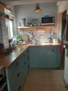 a kitchen with blue cabinets and a sink at הבית בואדי 