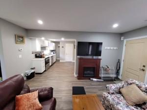 ein Wohnzimmer mit einem Sofa und einem TV in der Unterkunft Cozy 3-bedroom farmhouse in wine-country in Niagara on the Lake