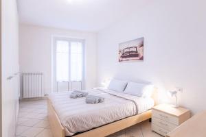 a white bedroom with a bed with two towels on it at [Esclusivo Loano centro] mare a 50 mt + Wi-Fi in Loano