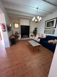 sala de estar con sofá y TV en Casa Rural Alzabara con Piscina Privada, en Taberno