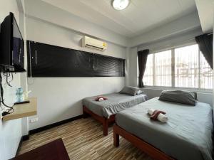 亚兰norndee hostel的一间带两张床、一台电视和一扇窗户的卧室