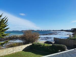 a view of a beach with a fence and the ocean at Le Prat - Santec in Santec