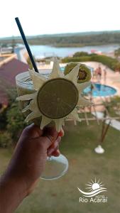 a person holding a drink with a slice of lime at Hotel Rio Acaraí in Camamu