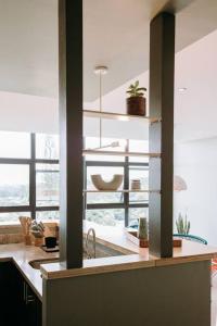cocina con fregadero y encimera con ventana en Wabi Salvi Apartment-A senses experience. en San Salvador