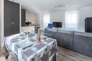 ein Wohnzimmer mit einem Tisch und einem Sofa in der Unterkunft KER UHEL - Charmant appartement plein centre in Saint-Renan
