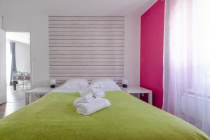 ein Schlafzimmer mit einem grünen Bett und Handtüchern darauf in der Unterkunft KER UHEL - Charmant appartement plein centre in Saint-Renan