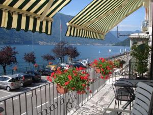 a balcony with flowers and a view of a body of water at Tremezzo Bella Vista - lake front - lake view in Tremezzo