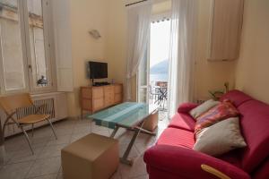 sala de estar con sofá rojo y mesa de cristal en Tremezzo Bella Vista - lake front - lake view en Tremezzo
