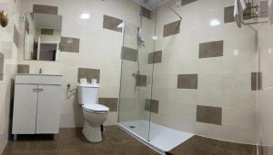 a bathroom with a toilet and a glass shower at Pensao Nova Goa in Lisbon