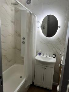 une salle de bain avec un lavabo, une douche et un miroir dans l'établissement Apart. Av. Corrientes, à Buenos Aires 22 autres photos