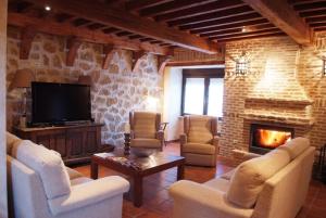 a living room with couches and a fireplace at La Casona de Doña Petra in Villarmentero de Campos