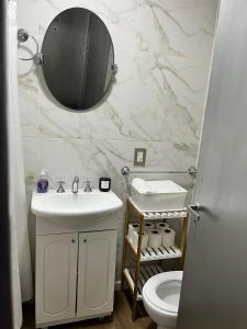une salle de bain avec un lavabo et un miroir et des toilettes dans l'établissement Apart. Av. Corrientes, à Buenos Aires