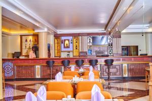 a restaurant with orange chairs and a bar at Wilsen Hotel Nansana in Kampala